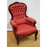 A Victorian mahogany show wood armchair, the shaped button back with foliage carved crest, the