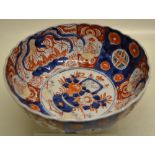 A Japanese Imari porcelain bowl the centre in rust and blue decorated a tub of flowers, the ribbed