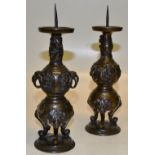 A pair of Japanese late nineteenth century bronze candlesticks, with iron prickets to the