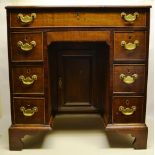 A mahogany veneered kneehole desk, the caddy moulded edge top above a long drawer and a small frieze