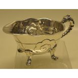An unusual Victorian rococo silver sauce boat, after Paul de Lamerie, of nautilus shell shape with a