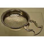 An early nineteenth century Scottish silver lemon strainer with a side handle and a rim clip, the