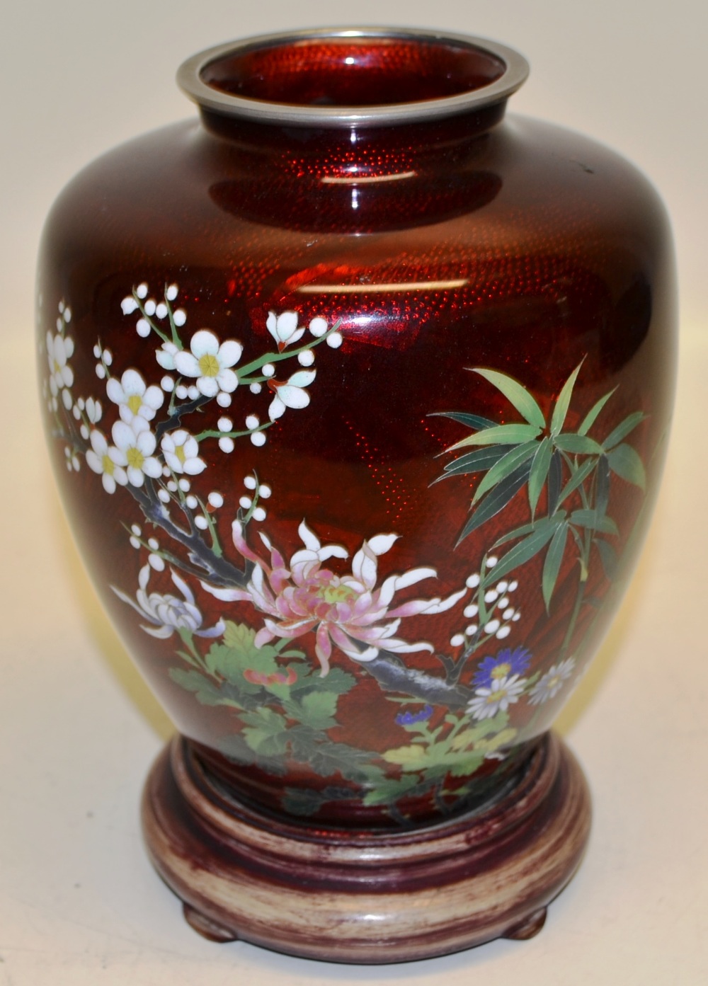 A Japanese red cloissone enamel vase, decorated coloured flowers and blossom. 7.25in (18.5cm) on a