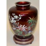 A Japanese red cloissone enamel vase, decorated coloured flowers and blossom. 7.25in (18.5cm) on a