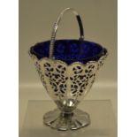 A Victorian circular silver swing handled basket, pierced fretwork panelled tapering sides with a