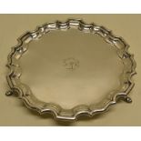 A silver circular salver, engraved a crest with motto, having a 'Chippendale' piecrust border on