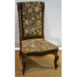 An early Victorian faded rosewood frame nursing chair, upholstered in floral needlework, acanthus