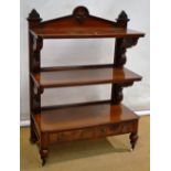 A mid Victorian Irish mahogany three tier buffet, with a raised back carved a cartouche and club
