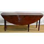 AMENDED An Irish mahogany wake table, the oval drop leaf top on square tapering