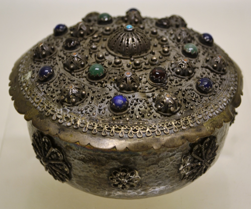 An Eastern silver coloured metal circular pot pourri jar, with a pierced cover set semi precious