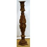 A Continental carved wood term, gilded foliage moulded scrolls to a terracotta ground, the stem