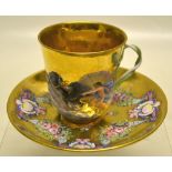 A nineteenth century Naples porcelain cup and saucer, the gilt ground with raised decoration of