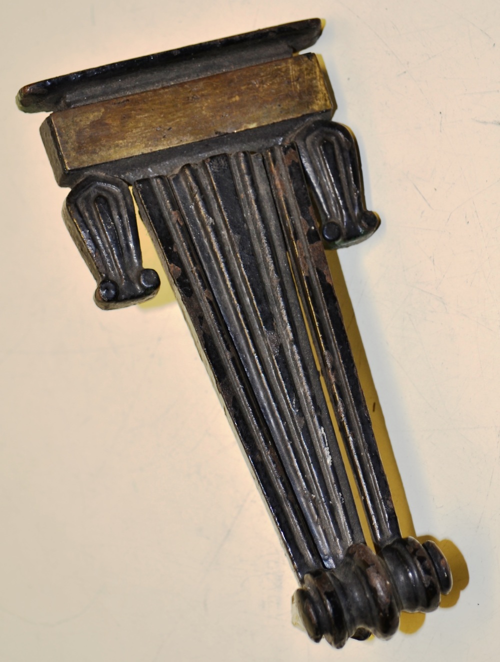 A Regency cast iron black painted door knocker, reeded tapering form with a brass plate and tulip