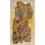 A Chinese late nineteenth century carved soapstone group of two children, being amused by a sage