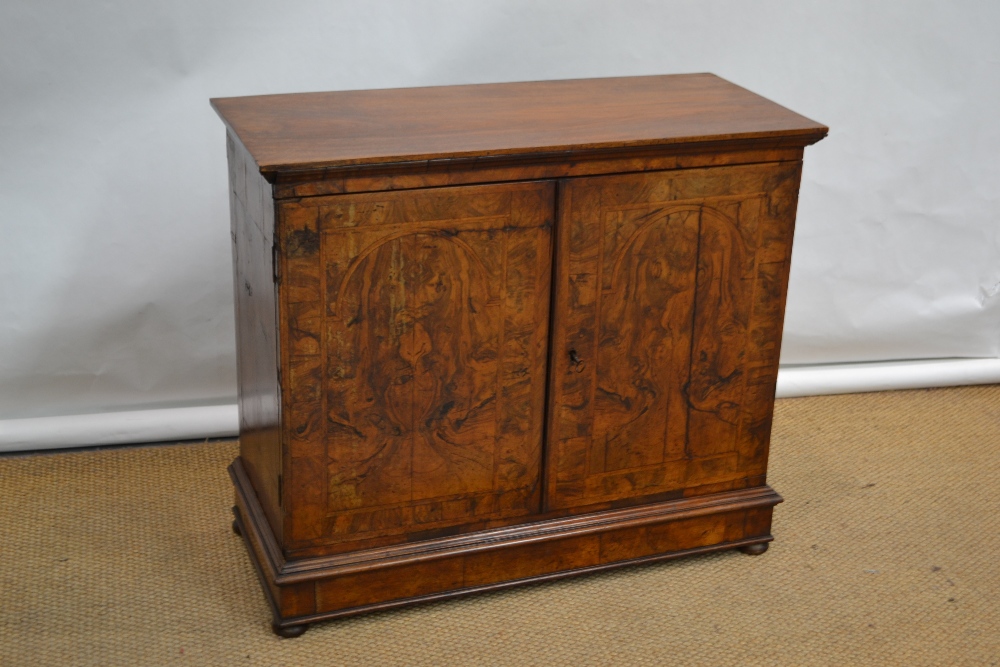 A William and Mary walnut veneered herringbone banded cabinet, the later top on a moulded cornice,