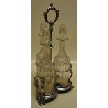 A Victorian electroplated tantalus with three cut glass decanters with stoppers, in a triform