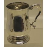 A George III silver half pint baluster mug, with a leaf capped scroll handle, on a moulded foot. 4.