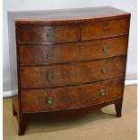 An early nineteenth century figured mahogany veneered bow fronted chest, the top edged with