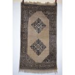 Two Tibetan rugs, first half 20th century, the first, cream field with dark brown and pale blue twin