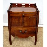 A George III mahogany bedside cupboard, the top with a pierced gallery with hand grips, a frieze