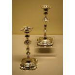 A fine pair of early George III cast silver candlesticks, the spool shape candle holders with