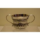 A Queen Anne silver child's porringer, part swirl fluted with florets, two scroll reeded handles,