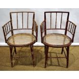 A pair of Regency beech simulated bamboo turned ladies armchairs, with remains of original red