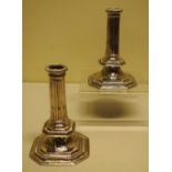 A pair of William III silver pillar candlesticks, the stop fluted hollow stems with gadroon edge