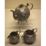An Indian silver three piece tea service, the globular bodies with repousse temple figures and