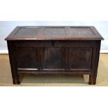 A seventeenth century oak coffer, the triple panel lid reveals later hinges and a lidded candle box,