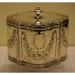A George III silver serpentine sided tea caddy, engraved with panels of floral festoons, a bright