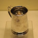 A silver pint mug, with capped scroll handle, the tuck-in base on a moulded foot. Makers Mappin &