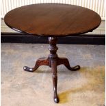 A George III mahogany occasional table, the circular one piece tilt top on a baluster turned stem to