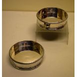 A pair of Regency silver decanter stands, the sides with gadroon borders, the silver bases with