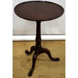 A George III mahogany occasional table, the circular dish moulded edge top on a vase ring turned