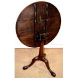 A late eighteenth century oak birdcage occasional table, the circular revolving tilt top on a