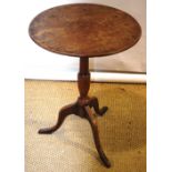 An early nineteenth century occasional table, the circular mahogany tilt top, on an ash vase