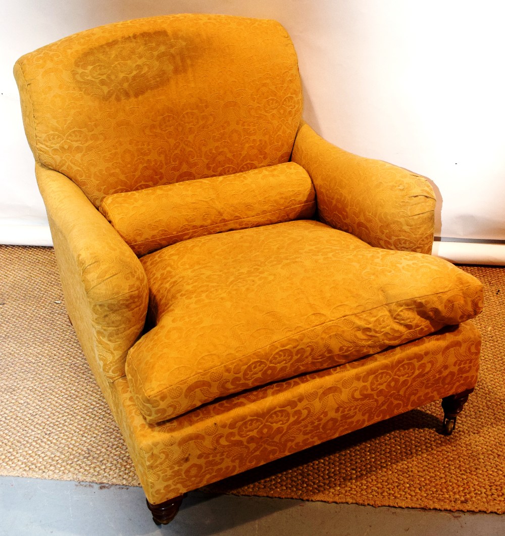 A late Victorian Howard & Sons easy armchair, upholstered in gold coloured figured material with