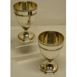 A pair of George III silver goblets, the bowls with repousse stiff leaves beneath and engraved