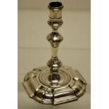 A George II cast silver taperstick, the spool shape holder on a baluster knopped stem, a welled