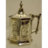 A Victorian silver mustard pot, the octagonal body engraved scrolling foliage, a pinnacle hinged