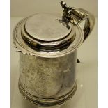 A William III silver quart tankard, engraved a coat of arms, the hinged lid with a fretwork front