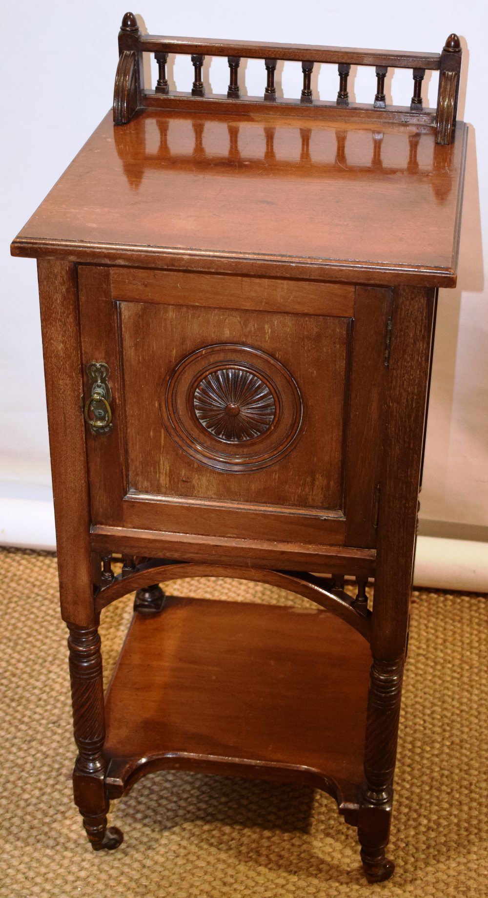 A Victorian walnut bedside cupboard in the manner of Charles Bevan, a balustrade to the back, the