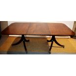 A mahogany twin pillar dining table, the fluted edge well figured rectangular top with rounded