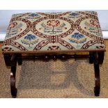 An early Victorian rectangular stool, the seat covered in needlework, the mahogany moulded scrolling