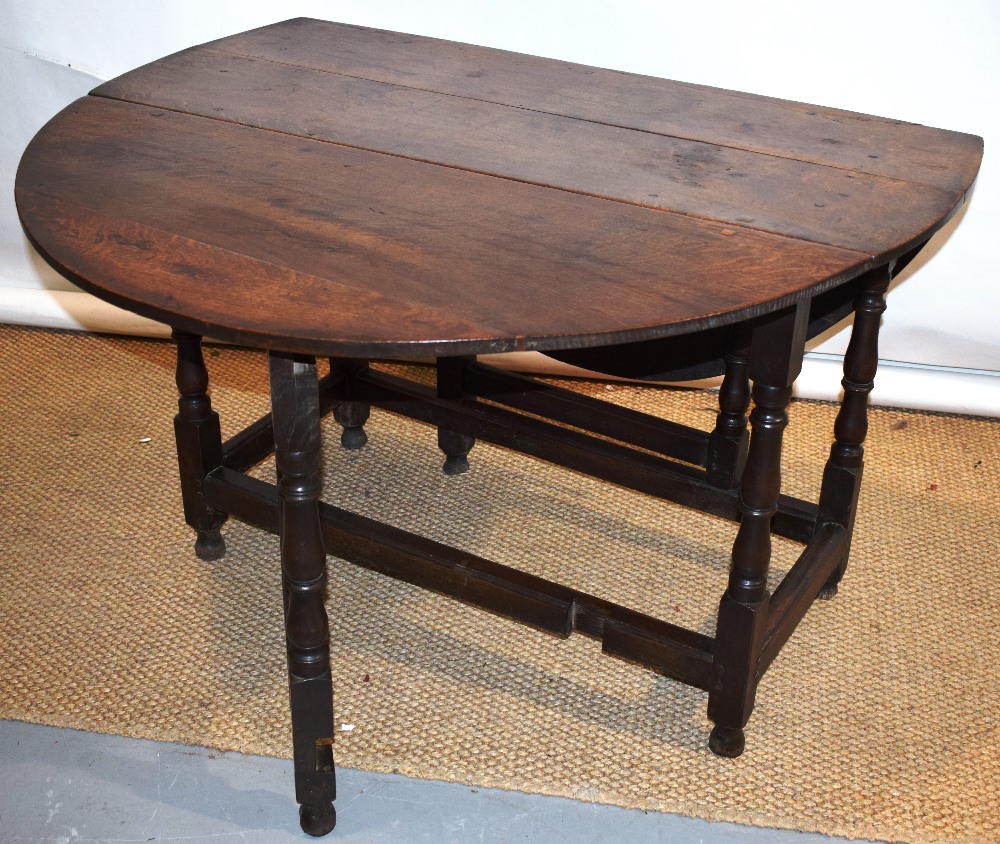 A late seventeenth century oak gateleg table, the oval drop leaf top on a frame with baluster turned