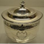 A George III silver oval tea caddy, engraved a band of foliage with a lock above initials, within