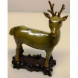 A nineteenth century Chinese pottery model of a deer, the olive green glazed body with green