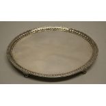 A George III silver oval salver, with a raised beaded and bell flower border, (slight old repair) on