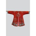 Chinese lady's informal robe, 19th century, red silk satin finely embroidered with three roundels of